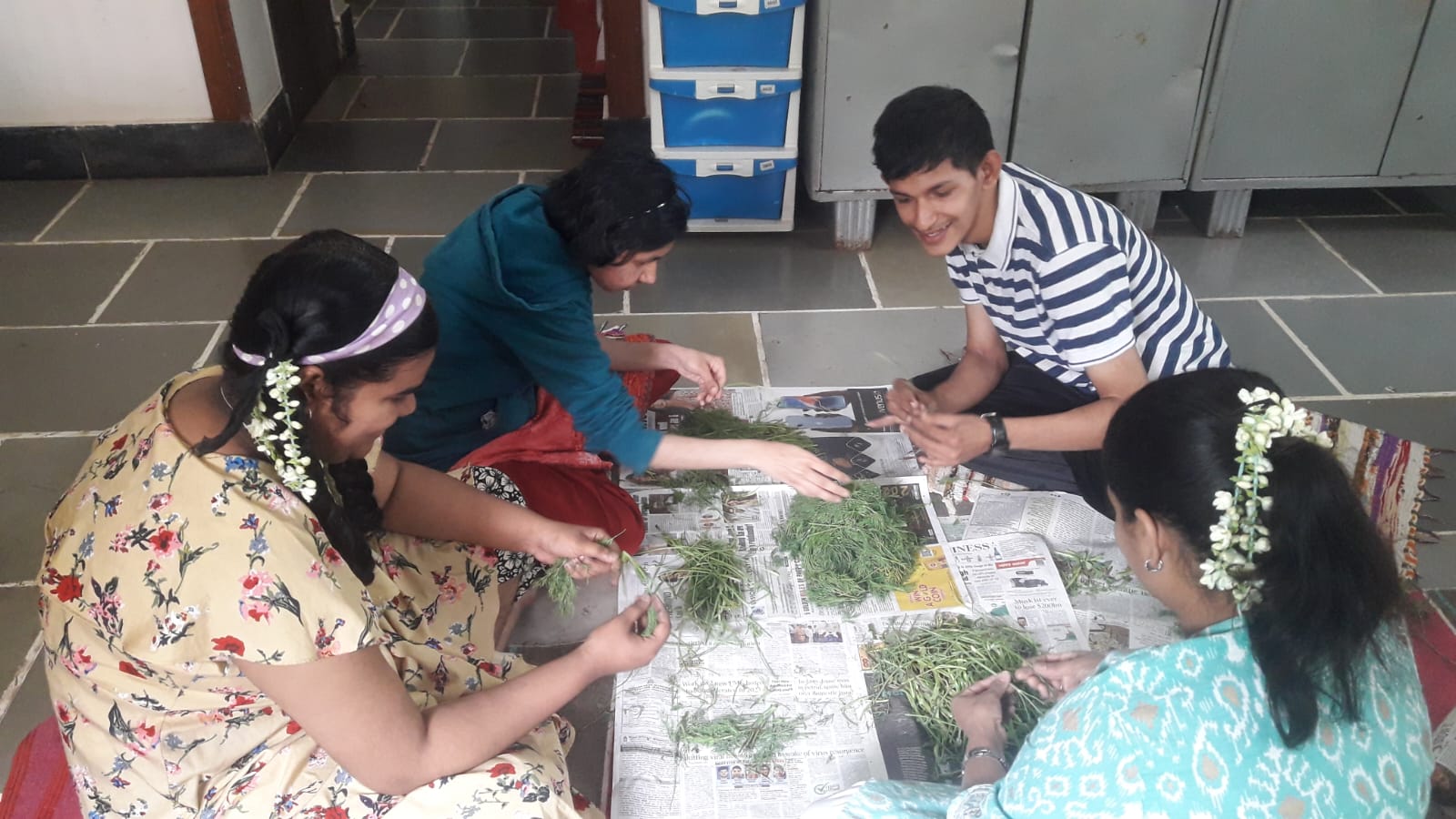 A participant and facilitator work together outdoors, filling a bag with compost material