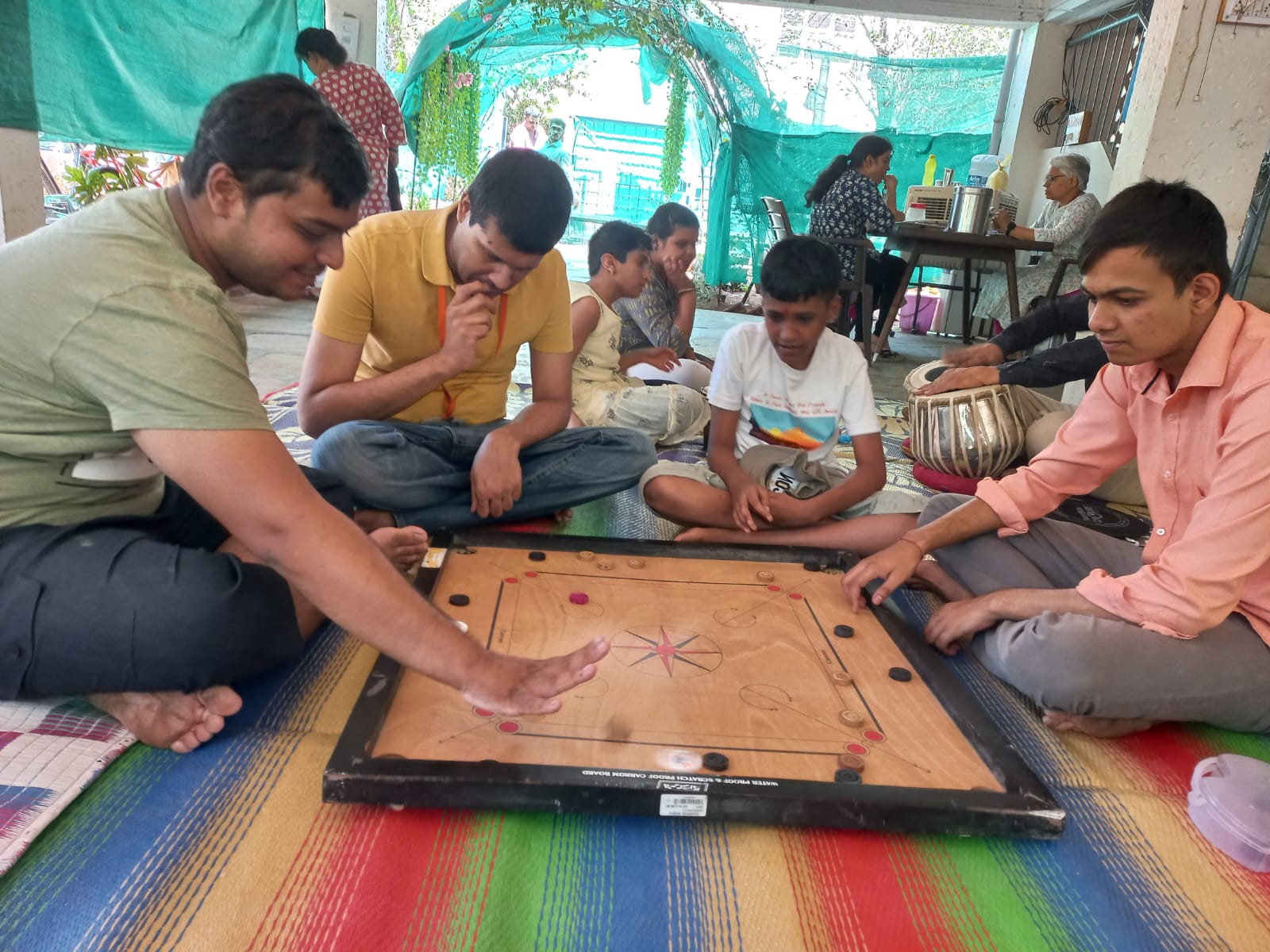 Members playing carrom together indoors